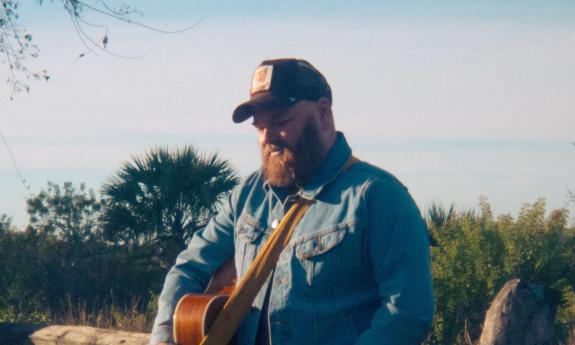 musician Kirk Whalen with his guitar, outside