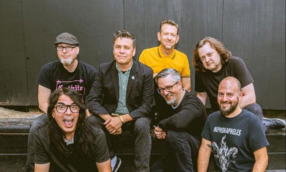 Ska band Mustard Plug sitting together, grinning