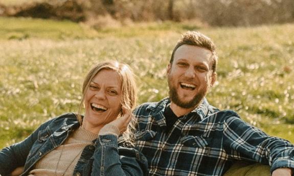 The Band Rough & tumble sitting in a grassy field, laughing