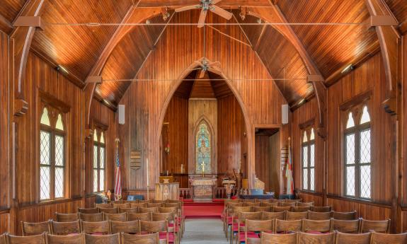 The interior of St. Cyprians with a deeply arched ceiling, looking toward the altar