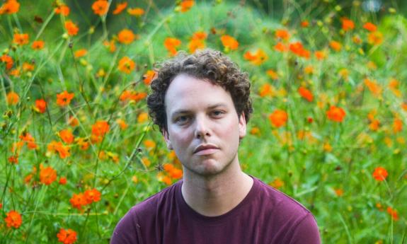 Composer and performer Tim Higgins, in a field of orange flowers
