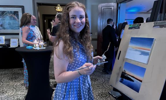 An artist presenting her work at the fundraiser