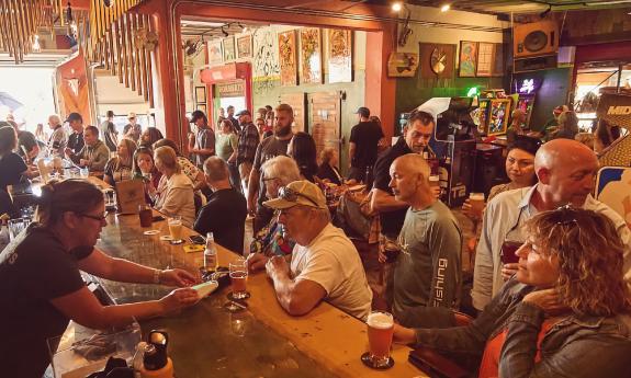 A busy bar, with open windows and lots of daylight