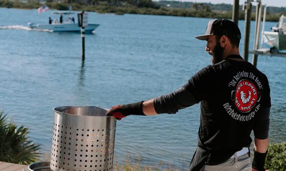 A outer banks boil chef prepares a seafood boil by the river