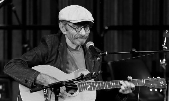 Roy Book Binder playing guitar live on stage