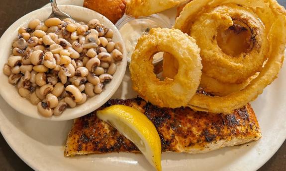  A meal of blackened fish, onion rings, and crowder peas on an old-style restaurant plate