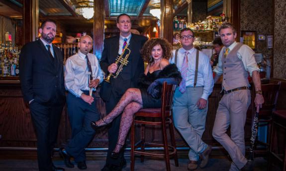Vocalist and band leader Svetlana with the five members of New York Collective arranged at a bar