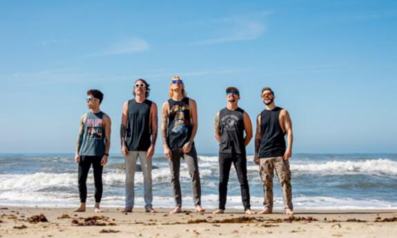 Bandmates from Ballyhoo!, Cydeways, and Beachfly wear glasses and pose on the beach.