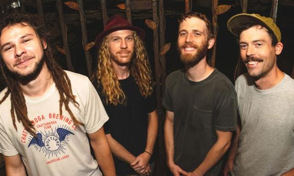 The band Dizgo standing together with a black background
