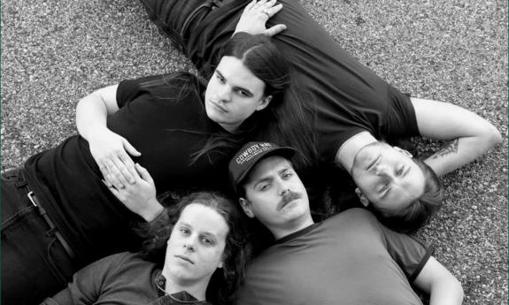 Four members of alt-rock band Lightwatch, lying on pavement