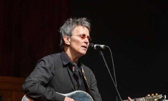 Songwriter Mary Gauthier, singing with her guitar, on stage