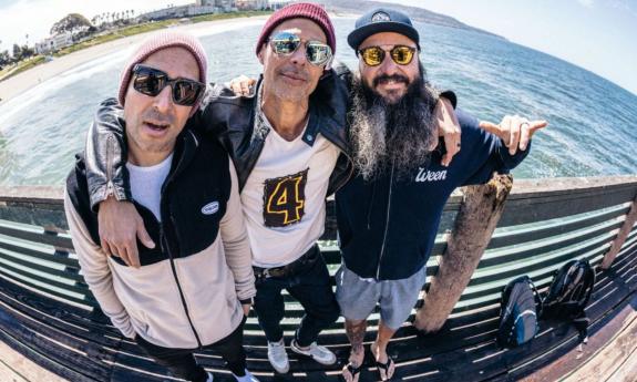 Bandmates from Pepper smile and pose on a pier.