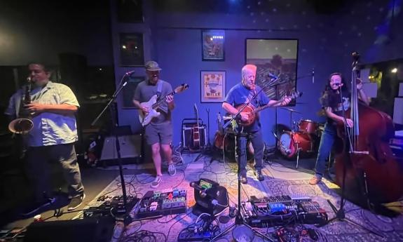 Billy Gilmore with three musician friends on stage