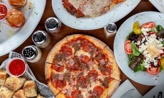 A spread of pizza, garlic knots, and salad