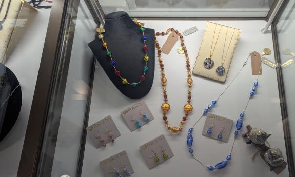 A jewelry display with necklaces and earings in a glass case
