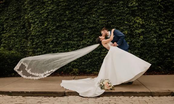 A bride and groom giving each other a quick kiss