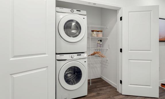 The stacked washer dryer are behind two doors with room for drying