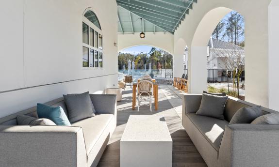 One outdoor lounge has a table and chairs and two sofas facing each other over a coffee table