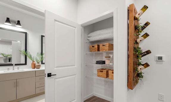 The apartment bath opens to the kitchen area, with a storage closet in between