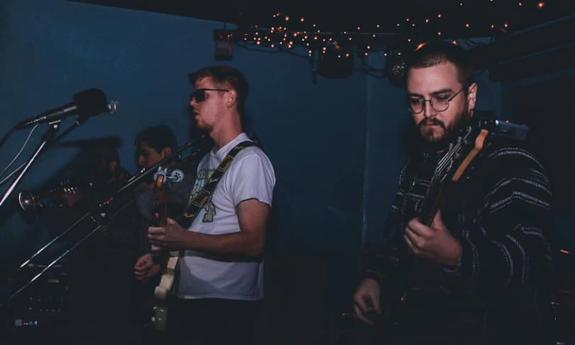 Bandmates from Lady Ybor perform live on stage.