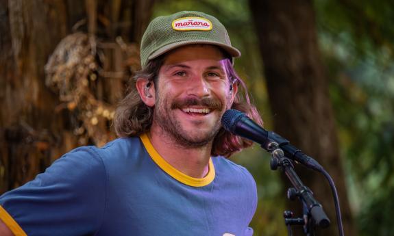 Carter Reeves, front man of Surfer Girl, smiling, in tropical setting