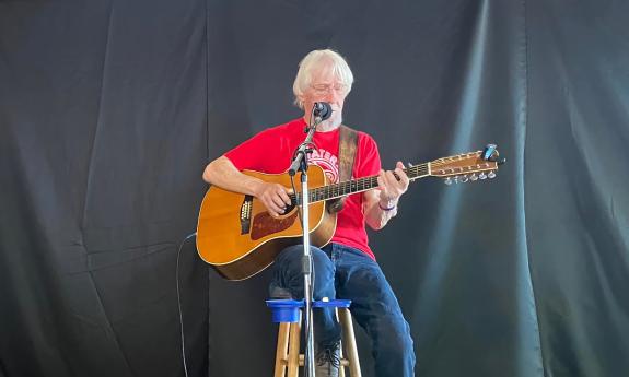Bob Patterson on an outdoor stage with a black backdrop
