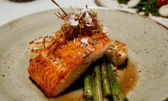 A dinner of salmon and asparagus on a white plate