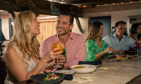 Two couples dining at a rooftop bar
