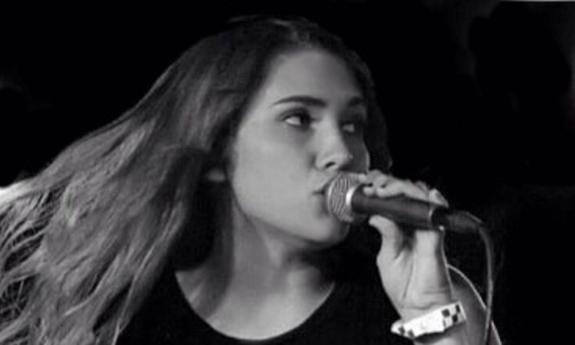 Songwriter Cassidy Lee singing into microphone
