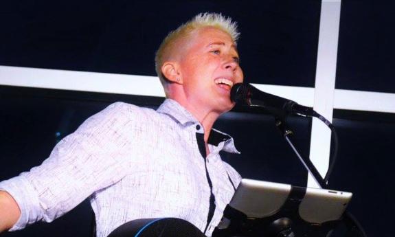 Songwriter Kristen Merlin singing at microphone