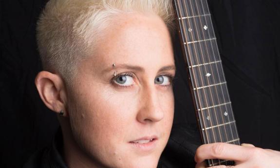 headshot of songwriter Kristen Merlin with her guitar