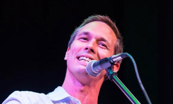 Singer songwriter Nick Norman singing at the guitar