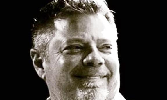 Songwriter Rodney Clawson, smiling, with black background