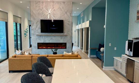 The community room features a two-sided fireplace, coffee bar, and multiple seating and lounge areas