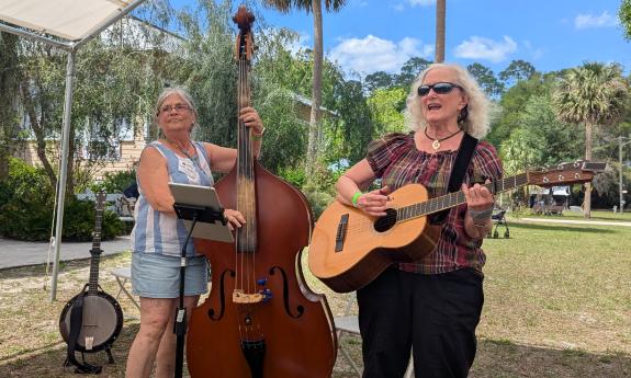 The duo Not Your Grandmother's Quilt performing outdoors under an awning