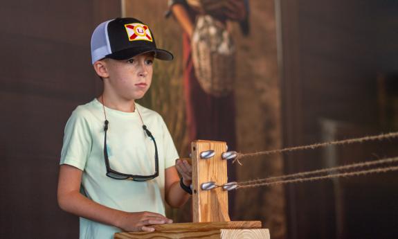 A young boy making rope at a museum in St. Augustine