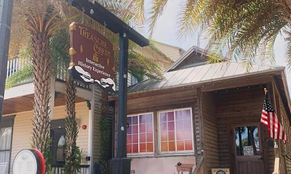 The entrance of the Treasure Chest is among palm trees