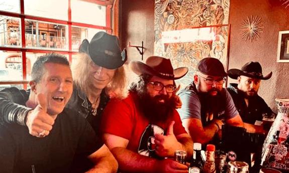 Members of the band Los Swamp Monsters sitting at a bar