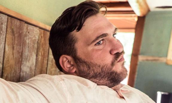 Singer-songwriter Zach Deputy in white shirt with skeptical look on his face