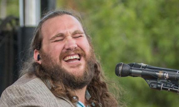 Singer-songwriter Zach Deputy onstage in front of a microphone