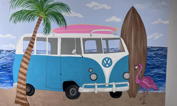 A mural of a van parked at the beach inside the shop