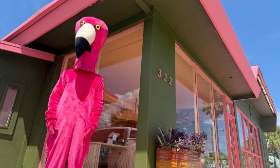The flamingo mascot in front of the cafe