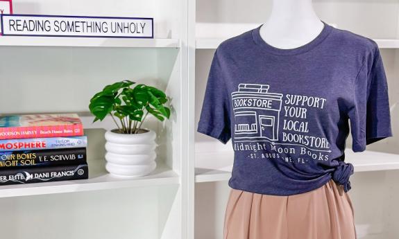 A mannequin dressed in a Midnight Moon Books & Boutique T-shirt