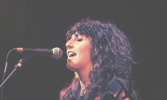 Miriam Morelli, singing onstage with a microphone