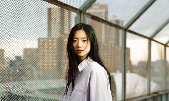 Songwriter-singer Sarah Kinsley standing with cityscape in the background