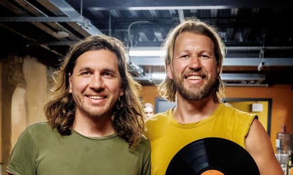 Teskey Brothers backstage, holding award record, grinning. 