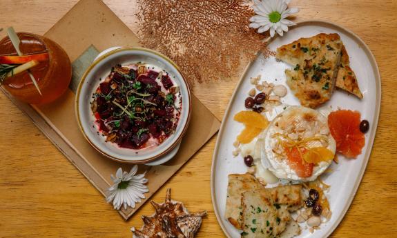 A beet poke bowl and baked brie on a plate