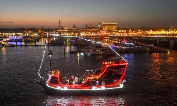 The Black Raven Pirate Ship cruising south of the Bridge of Lions in front of the Bayfront holiday lights