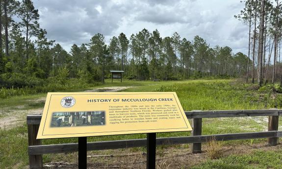 A trail sign explaining the history of McCullough Creek