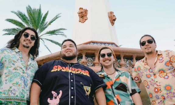 The band Dionysus standing outside under a palm tree